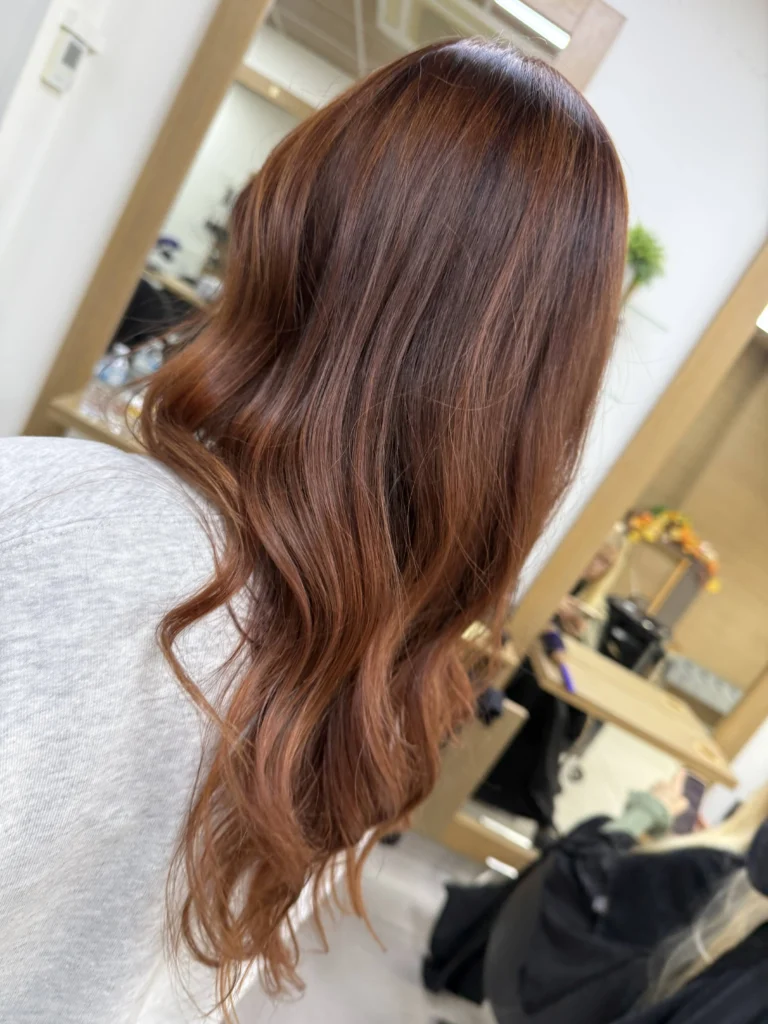 Long mahogany copper hair coloured with Wella Supernatural at Hair Culture salon Leytonstone, glossy red-brown waves